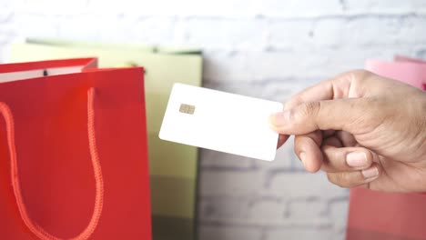 hand holding credit card with shopping bags