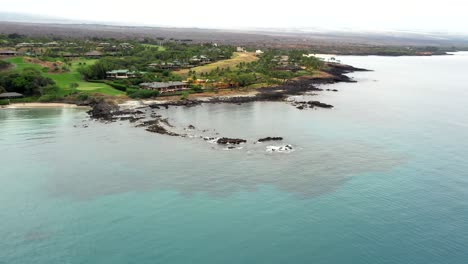 stunning blue crescent kauna'oa bay on kohala western hawaii coast aerial pull back shot