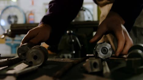 metalsmith looking at machine parts in workshop 4k