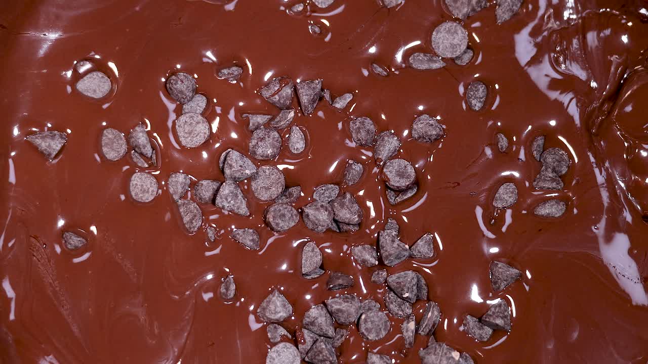 녹은 초콜릿 표면에 초콜릿 조각이 어져 있습니다.