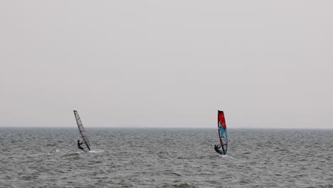 Wind-Surfer-Joined-by-Another-Wind-Surfer-Across-the-Water-on-an-Overcast-Day-in-Pattaya