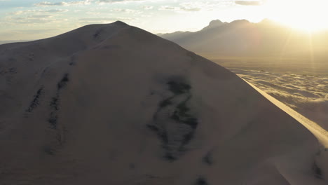 Toma-Aérea-De-Rayos-De-Sol-Golpeando-Las-Dunas-De-Kelson-Durante-La-Puesta-De-Sol