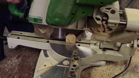 High-angle-view-of-a-craftman-is-working-on-electric-saw-machine.-Sawing-a-large-wooden-plank.-Dust-and-chips-are-scattering-on-the-floor.-Unrecognizable-person