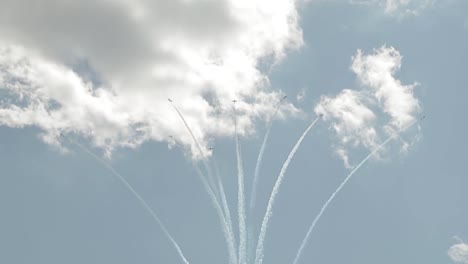 snow bird planes flying in formation, two planes breaking off