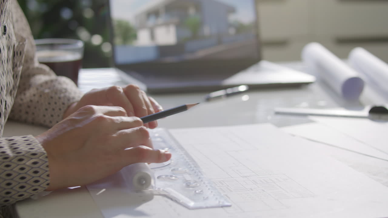 Close Up of Architect Creating Blueprint with Pencil and Ruler at Desk