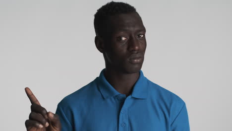 un hombre afroamericano con un fondo gris.