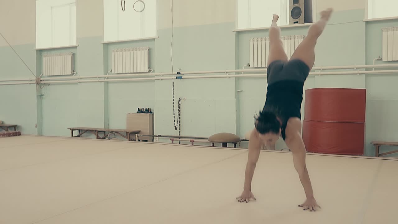 la chica es atlética en el gimnasio realiza un conjunto acrobático en cámara lenta