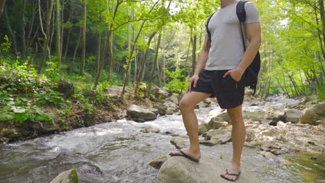 joven junto al arroyo en el bosque.