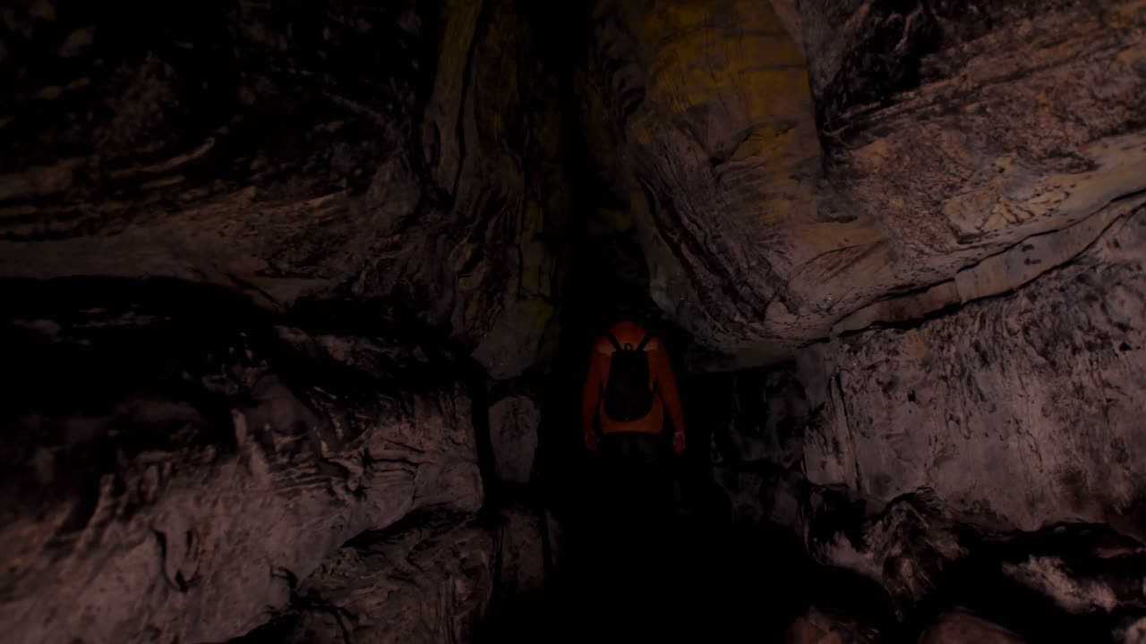 excursionista masculino explorando una cueva oscura 4k