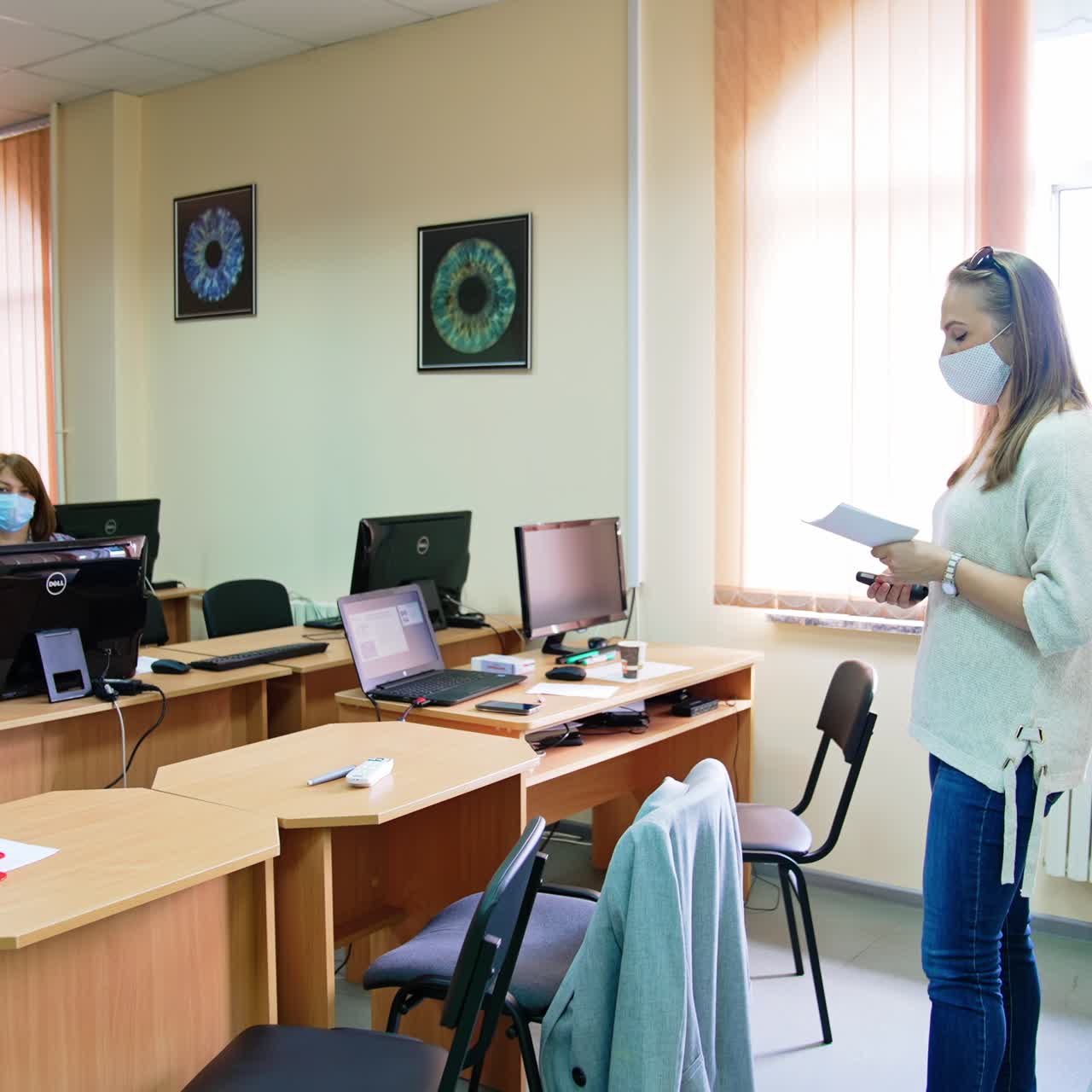 Lecture in medical university. Students sit at computers and the lecturer at the whiteboard reading a course