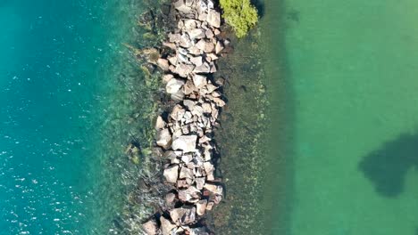 Vista-Aérea-De-Dos-Masas-De-Agua-Diferentes-Divididas-Por-Un-Muro-De-Ruptura-Hecho-Por-El-Hombre