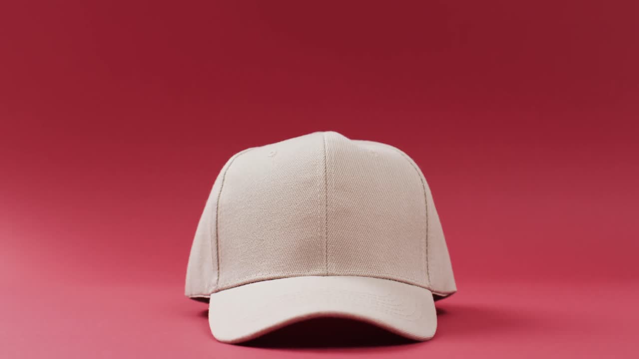 빨간색 배경에 베이지 야구 모자와 복사 공간의 비디오