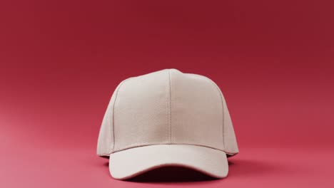 video of beige baseball cap and copy space on red background