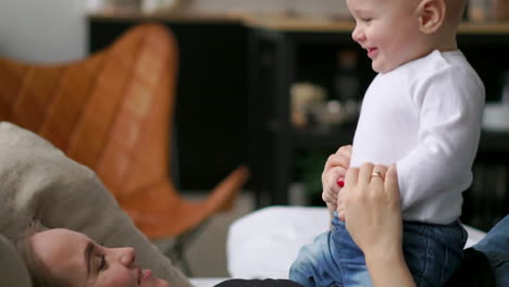 glückliche familie. mutter spielt mit ihrem baby im schlafzimmer. lacht und lächelt.