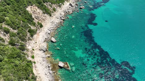 The-clear-blue-waters-along-corfu-island,-sunny-day-with-natural-coastal-beauty,-aerial-view