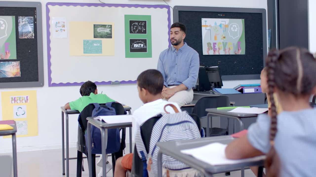 Young Asian man teaches in a vibrant school classroom