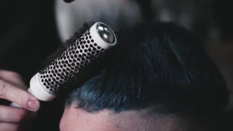 secar el cabello corto de un cliente masculino en una barbería