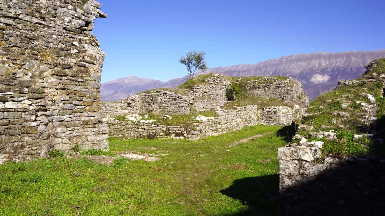 paredes de piedra en ruinas del castillo medieval con fondo de montaña en un día soleado