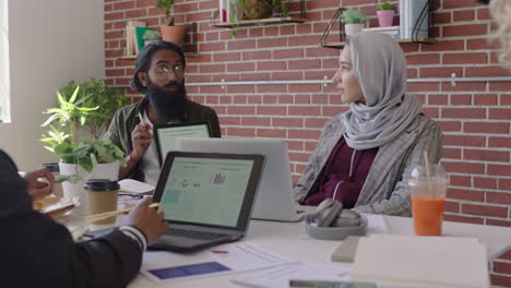 young-indian-businessman-using-tablet-computer-sharing-creative-ideas-presenting-project-showing-colleagues-in-office-meeting-diverse-team-working-together-brainstorming-planning-strategy