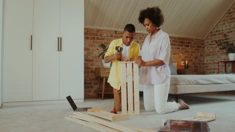 madre y hijo montando una caja de madera