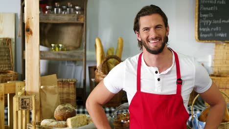 personal masculino sonriente de pie con la mano en la cadera