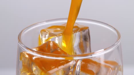 pouring orange juice with ice