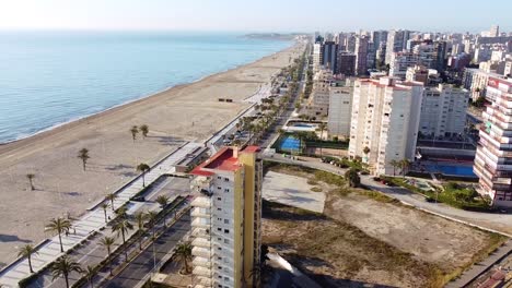 Aerial-drone-footage-of-new-buildings-with-swimming-pools-near-the-beach-of-San-Juan,-Spain