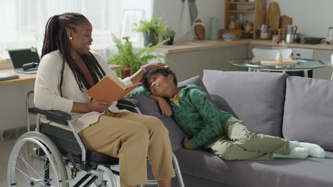 Mother in Wheelchair Reading Book to Son at Home