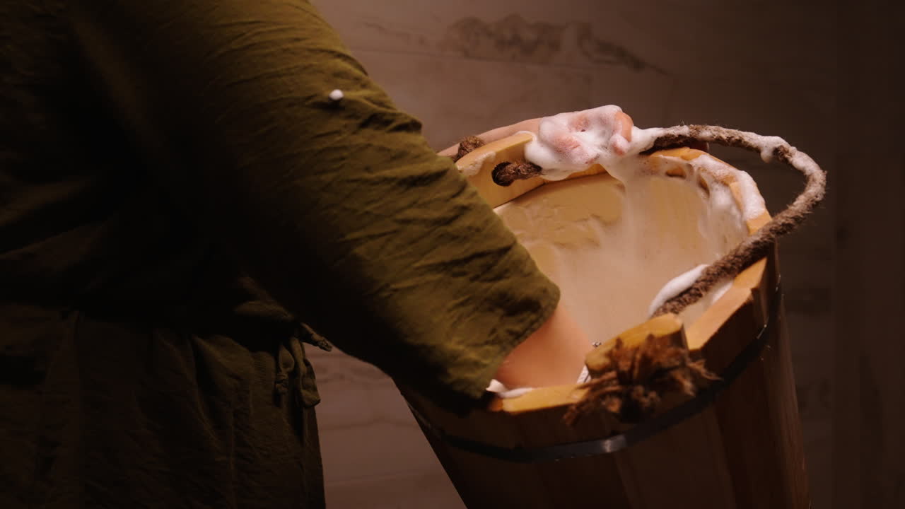 Woman enjoying a spa treatment with a wooden bucket