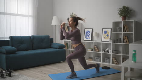 woman is jumping and squatting training alone at home fitness at quarantine and lockdown keeping fit and slender figure healthy lifestyle