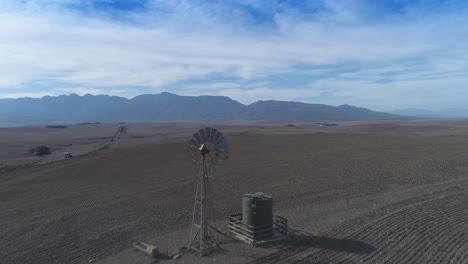 el dron vuela sobre tierras agrícolas secas y gira la bomba de viento durante el verano seco