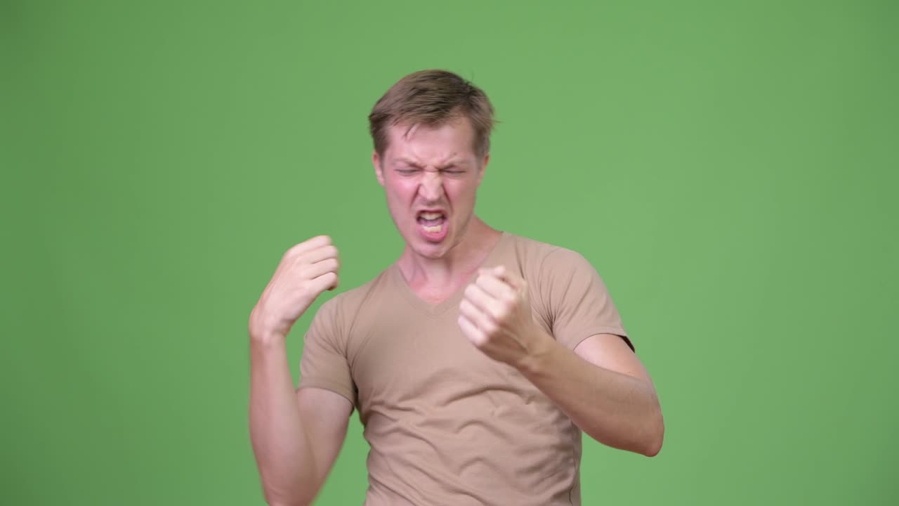 Young handsome Scandinavian man looking excited against green background