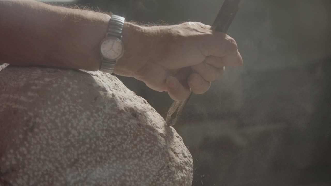 hombre artesanía su mano en una piedra polvorienta algunas formas artísticas con su propia técnica, italia.