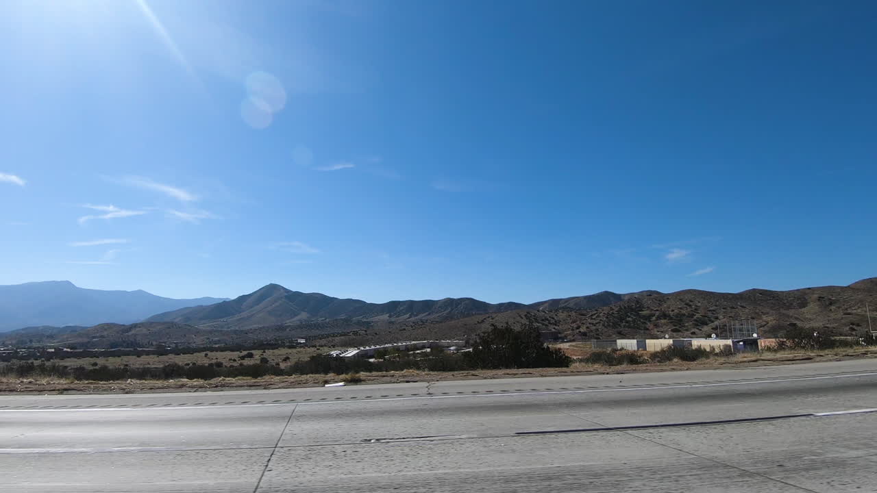 A large, white container truck traveling on the highway of Los Angeles