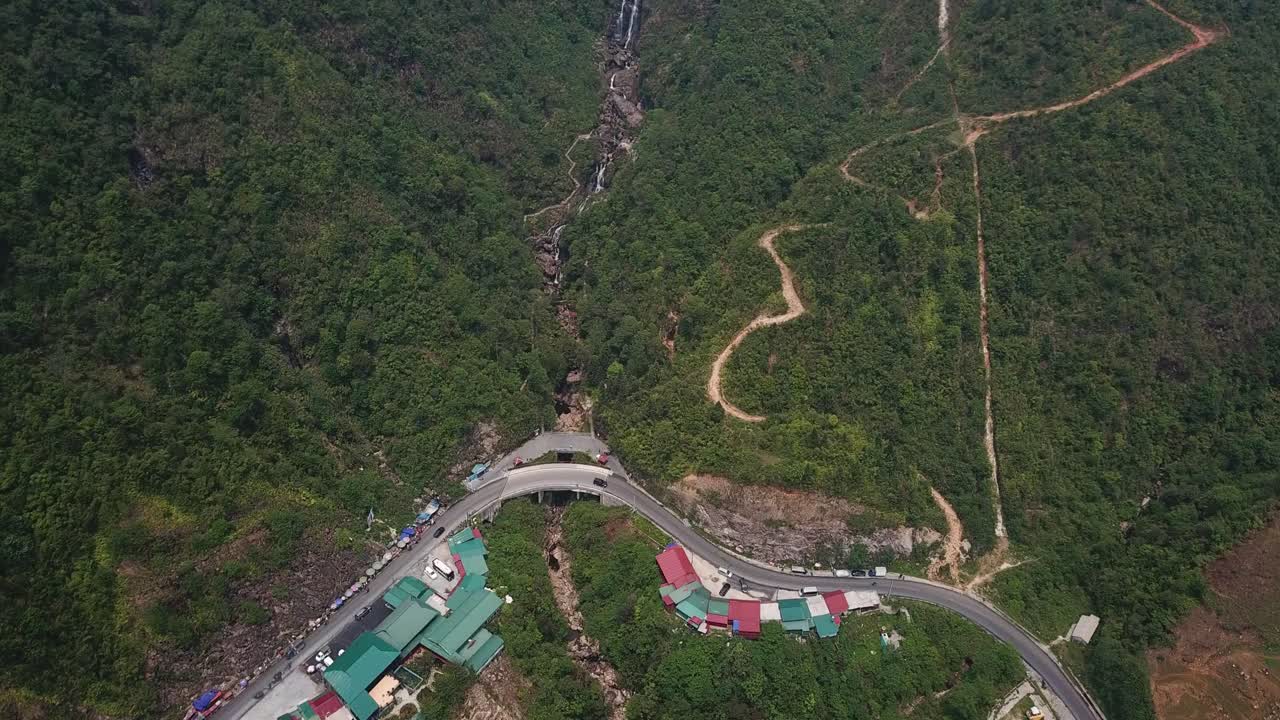 una vista aérea lejana directamente sobre un camino sinuoso y una cascada en sapa, vietnam