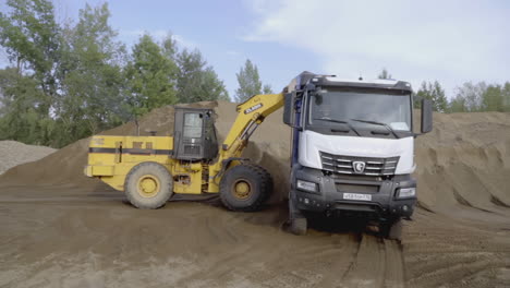 excavator loading truck with sand