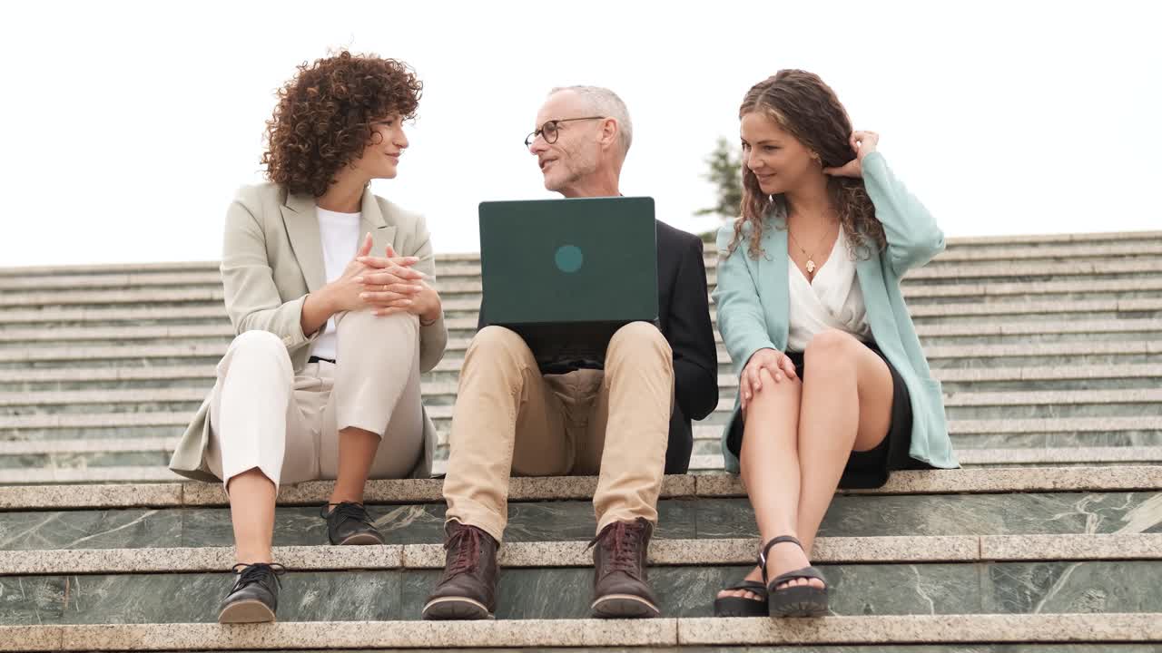 Group of businesspeople with netbook on steps
