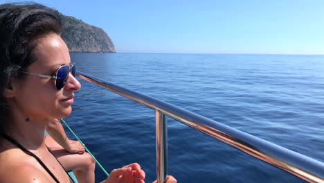 woman on a boat sailing through the mediterranean sea, along the coast of palma de mallorca