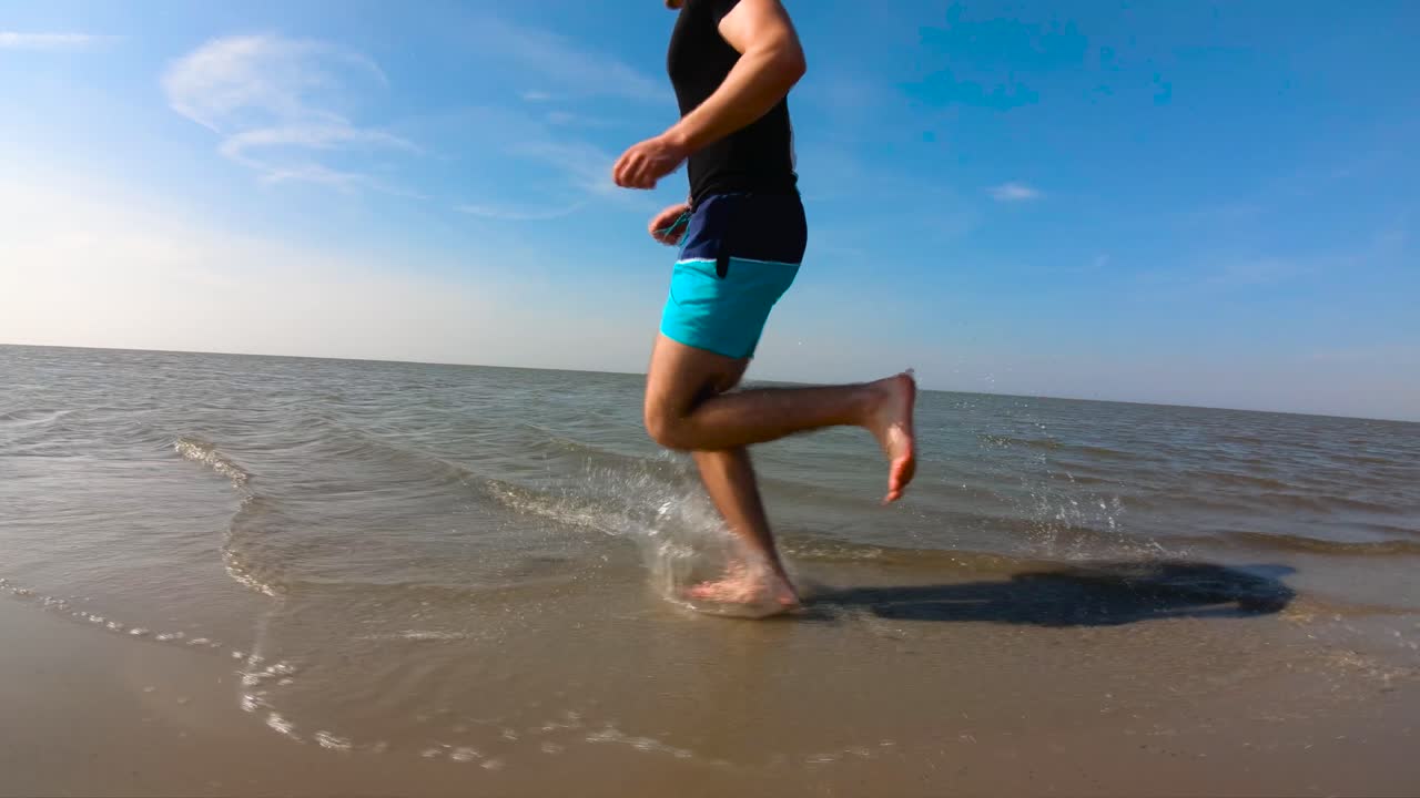 Guy running on the beach slow-motion