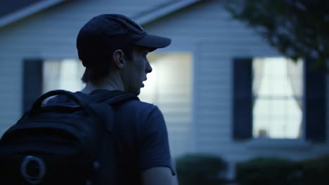 a mysterious encounter: a young man approaches a house at night, captivated by the illuminated windows and the atmosphere of intrigue surrounding him