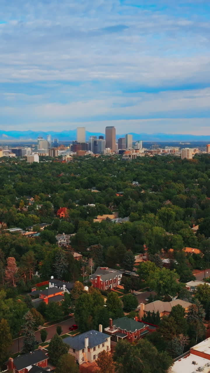 Descending over the green scenery of amazing Denver, Colorado, USA at daytime. Blue cloudy sky at backdrop. Vertical video