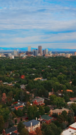 descending over the green scenery of amazing denver, colorado, usa at daytime. blue cloudy sky at backdrop. vertical video