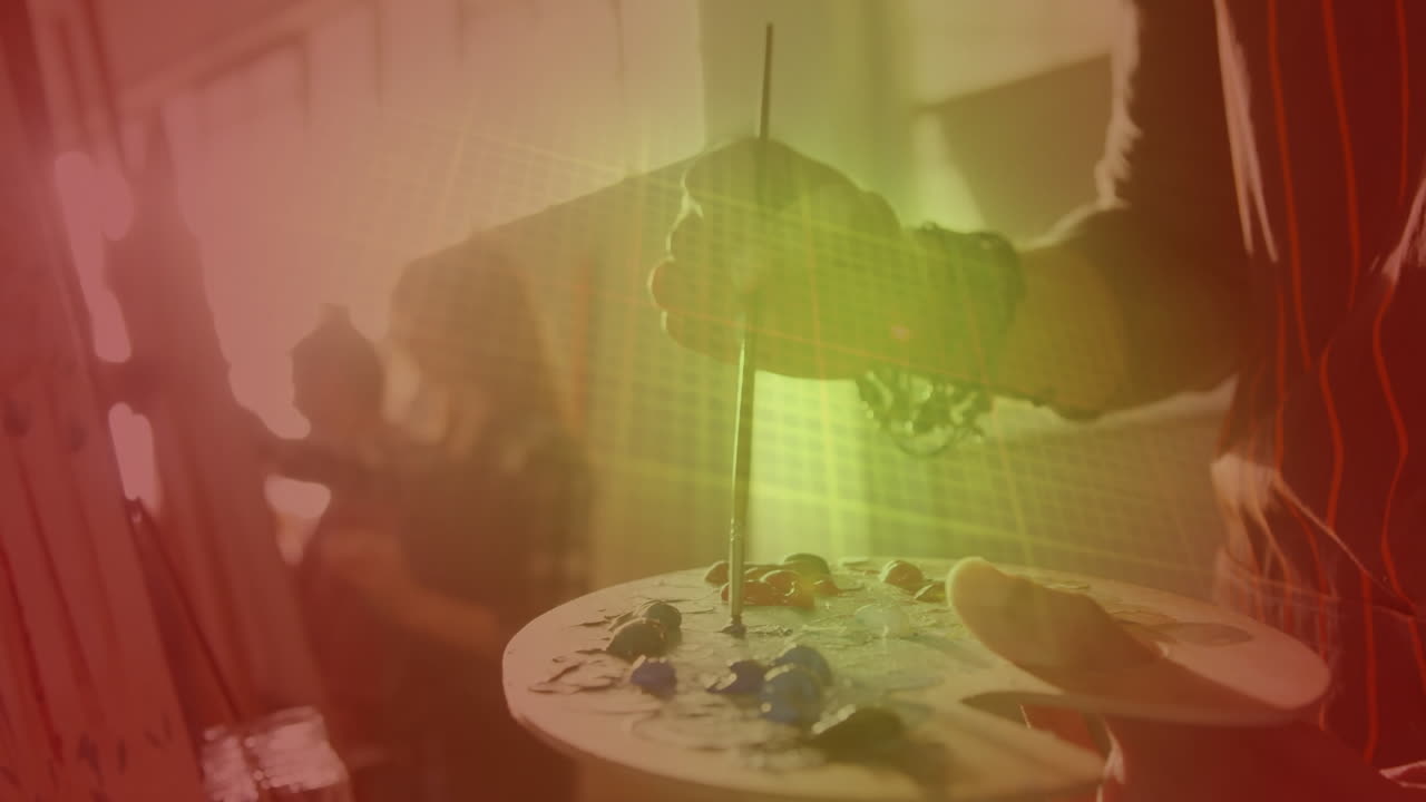 puntos de luz contra la sección media de una persona pintando en el estudio