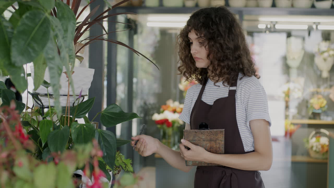 Florist Checking Plants in a Shop