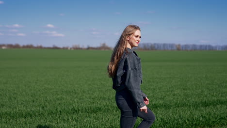 attractive young woman walking on green field. beautiful model with long fluttering hair on green nature background. slow motion.