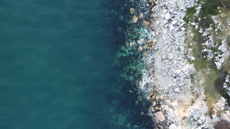 Toma-De-Paisaje-Cinemático-Aéreo-De-4k-De-La-Costa-En-La-Isla-De-Portland-Durante-La-Puesta-De-Sol,-Volando-Hacia-La-Playa-De-La-Iglesia-Ope