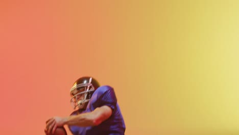 Video-Einer-Nahaufnahme-Eines-Kaukasischen-American-Football-Spielers-Mit-Helm-Und-Ball-Auf-Orangefarbenem-Hintergrund