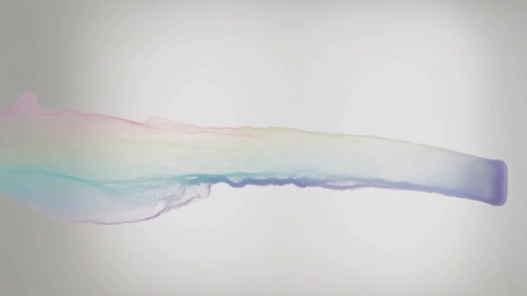 Un ugello corto rilascia un pennacchio color pastello verso sinistra in studio, formando sottili scie.