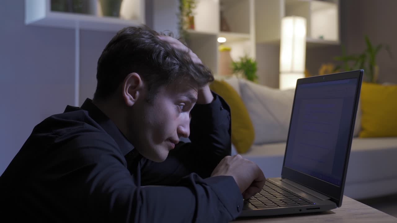 hombre estresado mirando la computadora portátil y trabajando en ella.