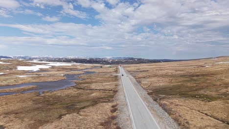 cars driving through norwegian national road 7 within the hardangervidda in norway. - aerial shot